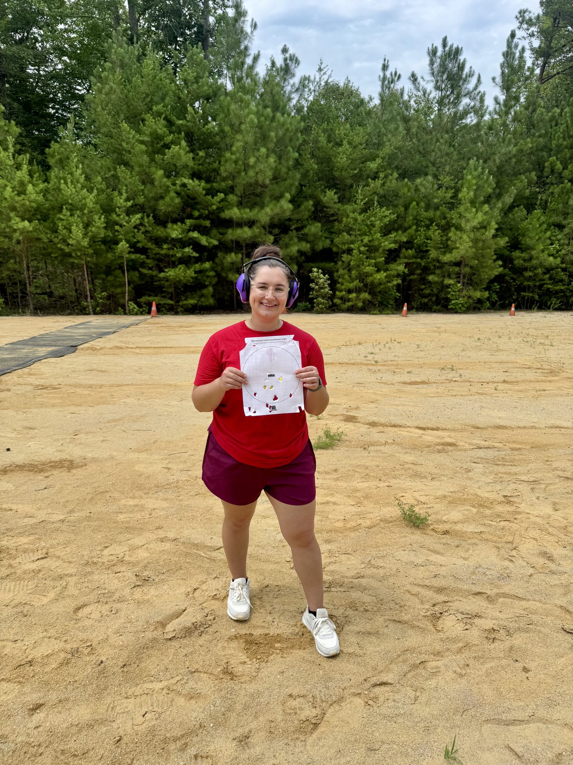 Happy student holding target after successful live fire practice