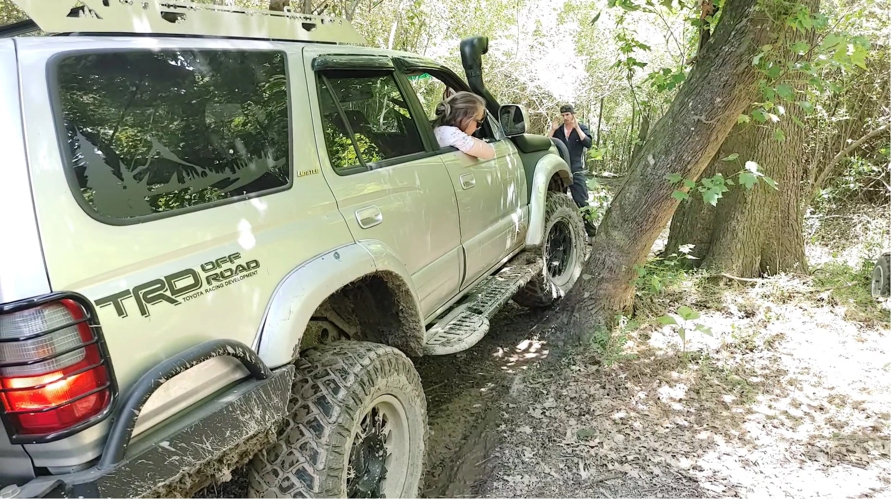Toyota 4Runner squeezing between trees on a tight trail