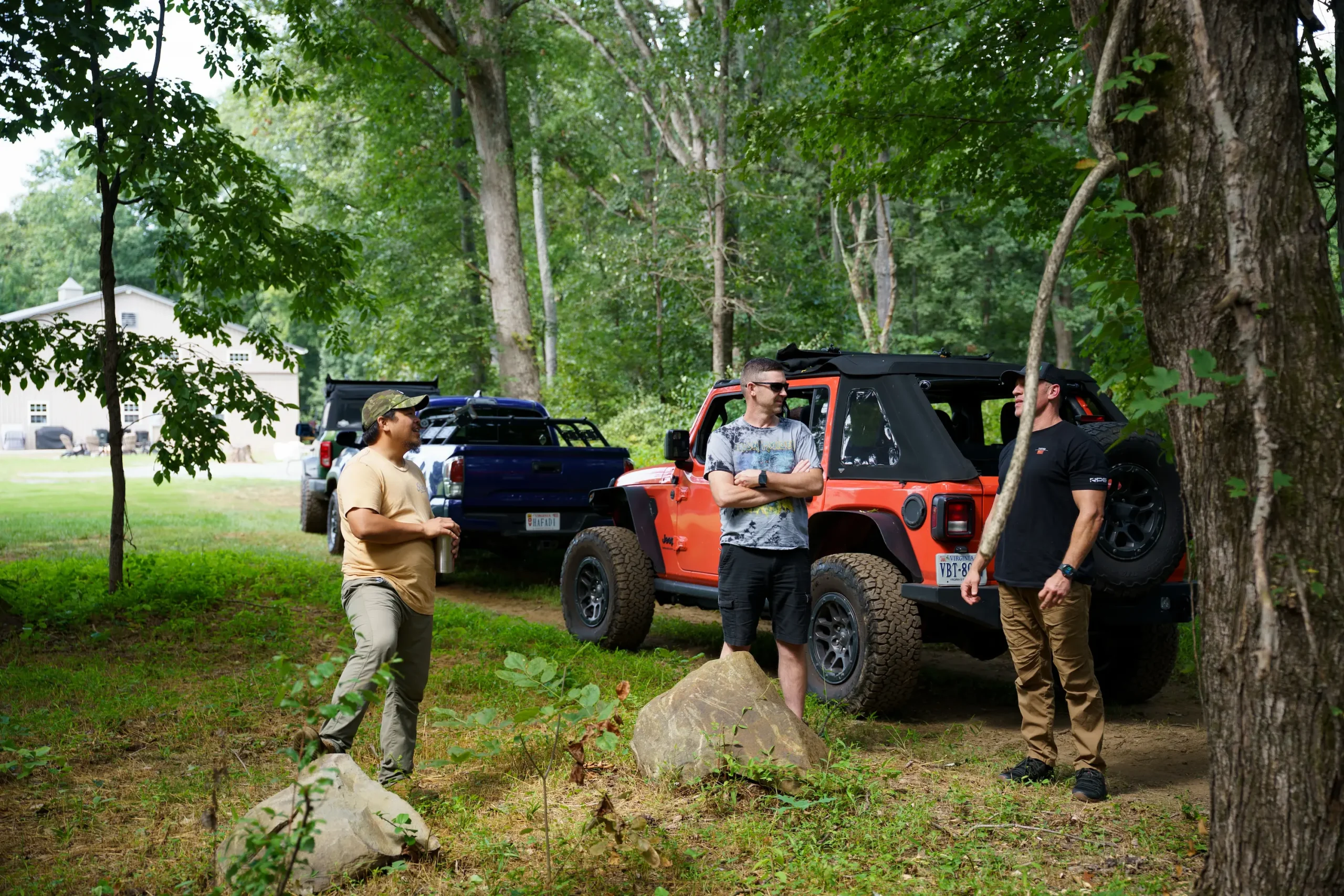 Friends gathered around a lifted Jeep at a Where2Wheel event